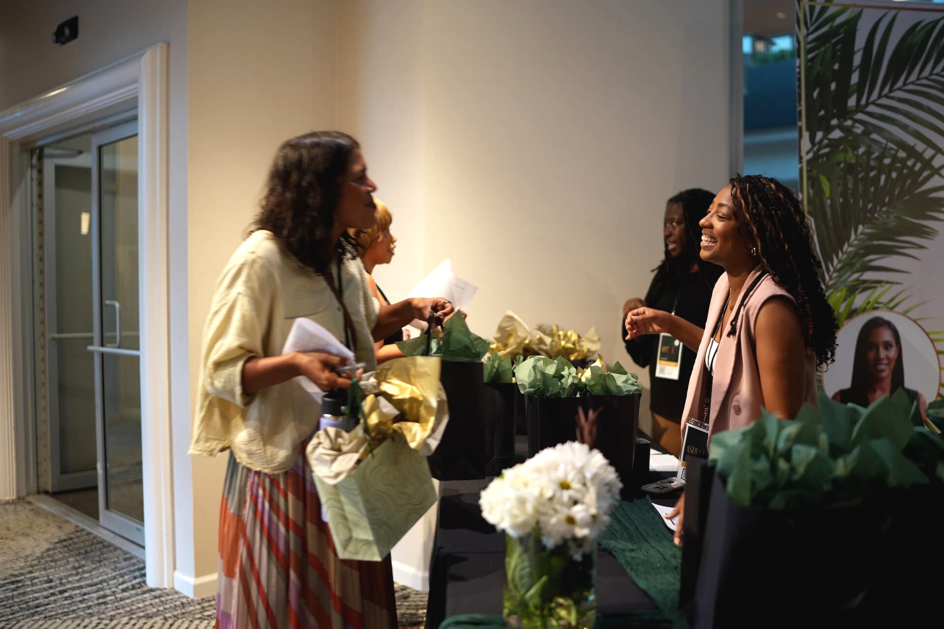 An attendee greeted by a staff member at the welcome and gift table